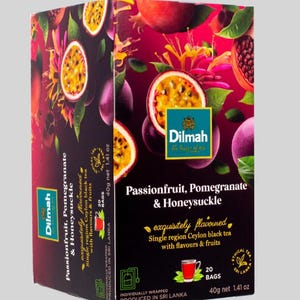 Könnte beinhalten: Eine Schachtel Dilmah-Tee mit den Geschmacksrichtungen Passionsfrucht, Granatapfel und Geißblatt. Die Verpackung zeigt Bilder der Früchte und Blüten. Der Text lautet "exquisit aromatisiert" Ceylon-Schwarztee, 20 Beutel, 40g netto.