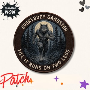 Può includere: Una toppa circolare ricamata raffigurante un lupo mannaro che corre attraverso una foresta scura con una luna piena sullo sfondo. Il bordo è marrone scuro con il testo "EVERYBODY GANGSTER TILL IT RUNS ON TWO LEGS" ricamato in lettere color crema.