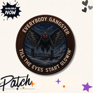 Pode incluir: Um emblema bordado circular apresentando uma mariposa escura com olhos vermelhos brilhantes pairando sobre uma ponte à noite. A borda é marrom com o texto "EVERYBODY GANGSTER TILL THE EYES START GLOWIN'" em letras cor de creme ao redor.