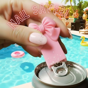 以下が含まれることがあります： ピンク色のリボンデザインのネイルセーバーがソーダ缶を開けています。「NAIL SAVER！」の文字が上に表示されています。背景には、人々やプールのあるプールパーティーが写っています。