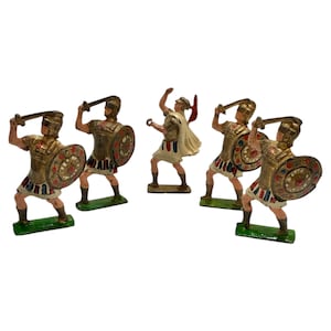May include: A set of antique toy soldiers, depicting warriors in gold, red, white, and blue attire. Each figure holds a sword or shield, standing on a green base. The collection evokes a sense of historical charm.