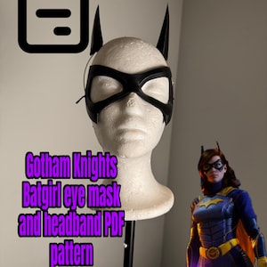 Puede incluir: Patrón PDF de máscara de ojos y diadema de Batgirl de Gotham Knights. La máscara negra se muestra en una cabeza de maniquí con orejas de murciélago negras. El texto "Gotham Knights Batgirl eye mask and headband PDF pattern" se muestra en púrpura.