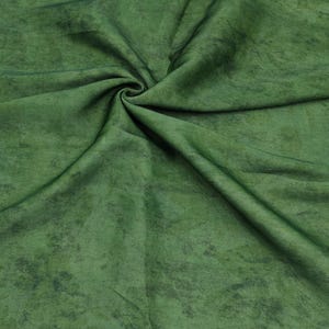 May include: Close-up of green fabric with a mottled texture. The fabric has a swirling pattern with darker green accents, creating depth. The material appears soft and pliable, suitable for textile projects. The overall effect is of a rich, textured textile.