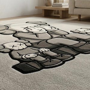 K&ouml;nnte beinhalten: Grau-wei&szlig;er Teppich mit einem sich wiederholenden Muster von Cartoonfiguren mit durchgestrichenen Augen und H&auml;nden, die ihre Gesichter bedecken. Der Teppich hat eine weiche Textur und einen dunkelgrauen Rand.
