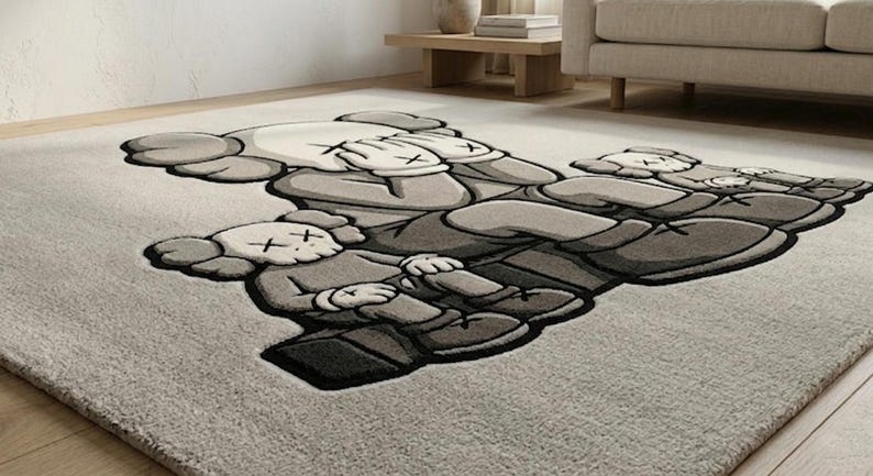 K&ouml;nnte beinhalten: Grau-wei&szlig;er Teppich mit einem sich wiederholenden Muster von Cartoonfiguren mit durchgestrichenen Augen und H&auml;nden, die ihre Gesichter bedecken. Der Teppich hat eine weiche Textur und einen dunkelgrauen Rand.