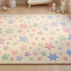 May include: A rectangular area rug with a cream-colored background featuring a repeating pattern of five-pointed stars in various sizes and pastel shades of pink, blue, green, and purple scattered across the entire surface of the rug.