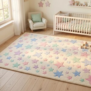 May include: A rectangular area rug featuring a cream-colored base adorned with a scattered pattern of stars in various sizes and pastel shades, including light blue, soft pink, and mint green, distributed across the entire surface of the rug.