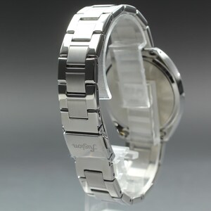 May include: A silver-toned wristwatch with a metal band. The watch is displayed on a clear stand, showcasing the band's links and the watch face. The word "fugon" is visible on the band.