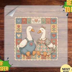 May include: DTF transfer featuring two cartoon geese, one in overalls and the other in a dress, within a decorative border of hearts and flowers. The words "READY TO PRESS" and "DTF TRANSFER" are visible.