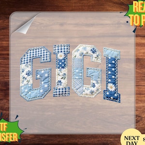 May include: A DTF transfer displaying the name "GIGI" in a patchwork style. The letters are in various shades of blue, incorporating floral and polka dot patterns. The transfer is on a clear sheet, with "READY TO PRESS" and "DTF TRANSFER" text.