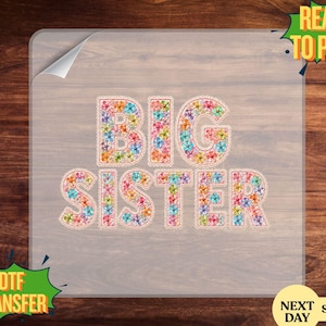 May include: A DTF transfer with the words "BIG SISTER" in large, colorful floral letters. The letters are outlined with a dotted stitch effect. The transfer is on a clear sheet with a corner peeled back, ready to press.
