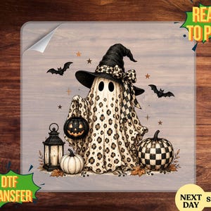 May include: A DTF transfer sheet featuring a ghost wearing a black witch hat with a leopard print pattern on its body. The ghost holds a small jack-o'-lantern, accompanied by a lantern, a white pumpkin, a checkered pumpkin, and flying bats.