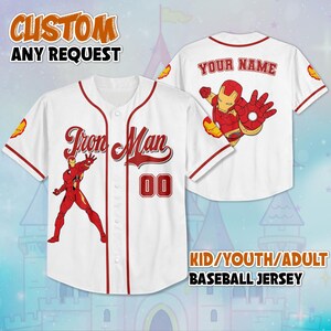 May include: White baseball jersey with red trim, featuring an Iron Man graphic on the front and back. The front displays "Iron Man" and the number "00". The back has space for a name. The jersey is available in kid, youth, and adult sizes.
