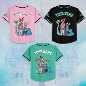 Puede incluir: Tres camisetas de b&eacute;isbol rosas, negras y turquesas, cada una con un gr&aacute;fico de dibujos animados de personajes de Zootopia. Las camisetas muestran "YOUR NAME" en la espalda y el logotipo de Zootopia en las mangas.