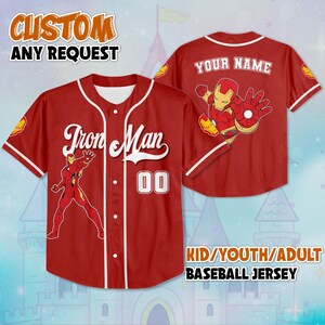 May include: Red baseball jersey with white trim, featuring "Iron Man" text and a graphic of the character. The jersey includes the number "00" and the text "YOUR NAME" on the back. The text "CUSTOM ANY REQUEST" is also visible.