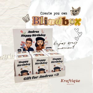 May include: A display of personalized blind boxes for a birthday. The boxes are white with the text "Happy Birthday" and a cartoon image. The display also features the text "Create you own Blindbox" and "Gift for Andrea <3".