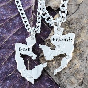 May include: Two silver necklaces with wolf-shaped pendants that fit together. The pendant on the left says "Best" and the pendant on the right says "Friends".