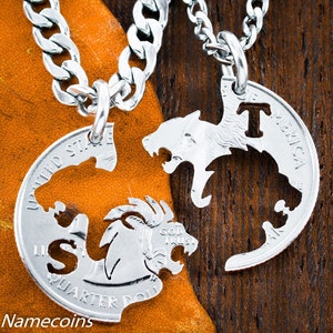 May include: Two silver necklaces with matching wolf pendants. The pendants are cut out of US quarter coins and are designed to fit together. The necklace on the left has the letter "S" and the necklace on the right has the letter "T".