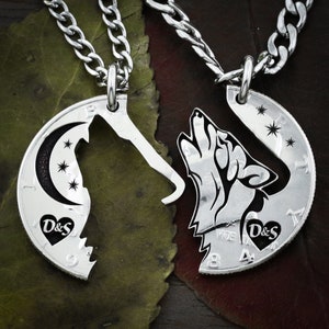 Könnte beinhalten: Ein Paar silberne Halsketten mit Wolf-Silhouetten, die aus US-amerikanischen 50-Cent-Münzen ausgeschnitten sind. Die Wolf-Silhouetten sind einander zugewandt und die Münzen sind durch silberne Ketten verbunden. Die Münzen sind mit dem Text "D&S" graviert.