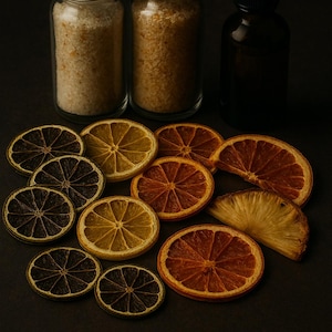 May include: A still life arrangement featuring two glass jars with silver lids filled with coarse granules, a dark brown dropper bottle, and several dried citrus slices in shades of brown, yellow, and orange. The items are arranged on a dark surface.