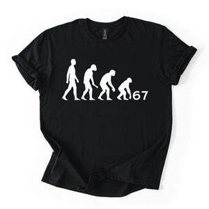 Può includere: T-shirt nera con grafica evolutiva bianca che mostra figure che cambiano postura, culminando con il numero "67". La maglietta è realizzata in materiale morbido ed è adatta per l'abbigliamento casual.