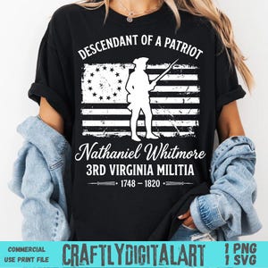 May include: Black t-shirt with a white graphic of a colonial soldier in front of a distressed American flag. Text reads "Descendant of a Patriot" and "Nathaniel Whitmore 3rd Virginia Militia 1748-1820".