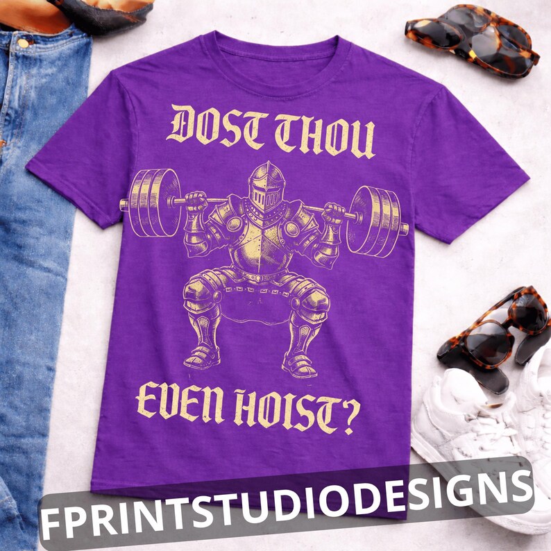 K&ouml;nnte beinhalten: Lilafarbenes T-Shirt mit einem goldenen Motiv eines Ritters, der Gewichte hebt, und dem Text "DOST THOU EVEN HOIST?". Sonnenbrille und Turnschuhe sind im Hintergrund zu sehen.