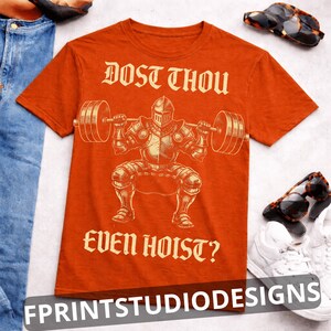 K&ouml;nnte beinhalten: Orangefarbenes T-Shirt mit einem Ritter, der Gewichte hebt, und dem Text "DOST THOU EVEN HOIST?" im Vintage-Stil. Das Shirt hat auch den Text "FPRINTSTUDIODESIGNS" unten.