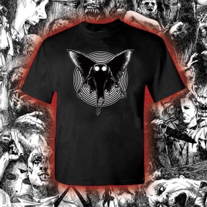 May include: Black t-shirt with a white graphic of a moth-like creature with large eyes. The creature is surrounded by a swirling pattern.