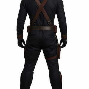Pu&ograve; includere: Tuta tattica nera con dettagli in pelle marrone, tra cui bretelle, cintura e cinghie per le gambe. L'outfit presenta tasche multiple e guanti. Gli stivali sono marroni. Per cosplay o costume.