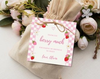 May include: A beige drawstring bag with a pink and white checkered tag. The tag features strawberries and the text "Thank you berry much for making my birthday so sweet, love, Olivia."