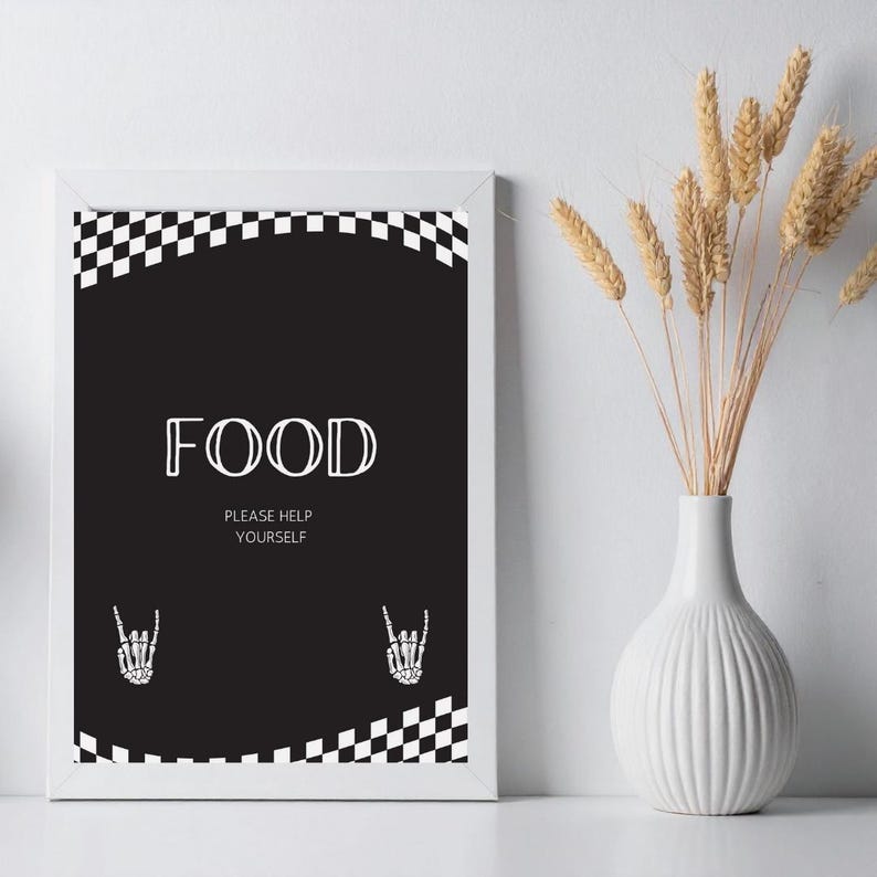 May include: A framed black and white sign with the word "FOOD" in a bold, stylized font. The sign also includes the text "PLEASE HELP YOURSELF" and two skeleton hand illustrations. A checkered pattern borders the top and bottom of the sign.