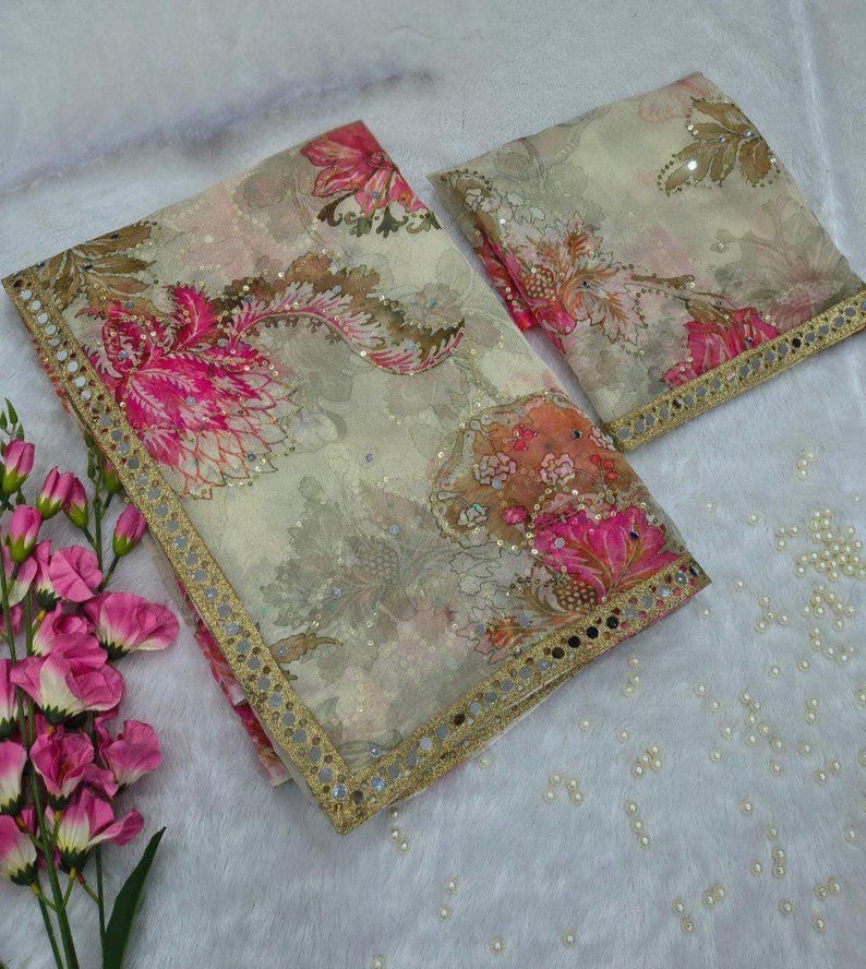 May include: Two-piece floral fabric set with a cream background and pink and brown floral patterns. The edges are trimmed with a gold border. The fabric is decorated with small sequins. The set is placed on a white, fluffy surface.