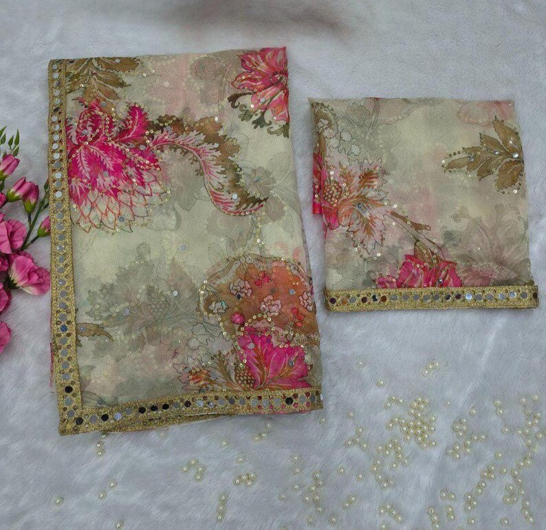 May include: A two-piece floral patterned fabric set. The fabric has a cream background with pink, brown, and orange floral designs. The edges are trimmed with a gold border and small mirrors. The set is likely a scarf and matching fabric.