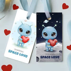 May include: Two illustrated bookmarks featuring a blue alien holding a red heart. One bookmark has a light blue background with stars and a planet, the other has a dark blue space background. The text "SHARING SPACE LOVE" is printed on both.