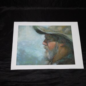 Op de afbeelding: Een schilderij van een mannengezicht in profiel, met een breedgerande hoed. De man heeft een lange baard en kijkt naar de zijkant. Het schilderij is gemaakt in een zachte, gedempte kleurenpalet van blauw, groen en bruin.