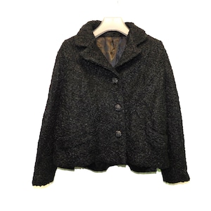 May include: A black, fuzzy, short-sleeved jacket with a button closure.