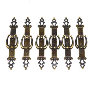 May include: A white ceramic mug with a black handle and the text "But First, Coffee" in a handwritten style. The mug is on a white surface. The mug is approximately 4 inches tall.