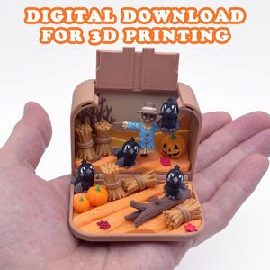 May include: A small, open, tan-colored box containing a miniature autumn-themed diorama with a scarecrow, black birds, pumpkins, and hay bales. The text "DIGITAL DOWNLOAD FOR 3D PRINTING" is displayed in orange letters above the object.