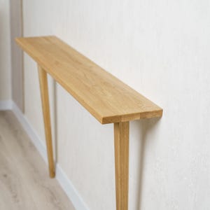 Könnte beinhalten: Ein Set aus drei Keramikbechern mit gesprenkelter, matter Oberfläche. Die Becher sind in Creme-, Hellgrau- und Dunkelgrautönen gehalten. Jeder Becher hat ein schlichtes, minimalistisches Design.