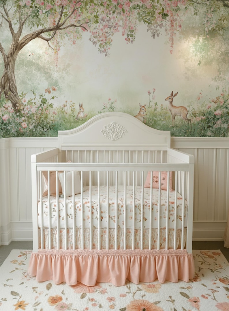 May include: A white cot with a floral patterned sheet and a pink ruffled cot skirt. The nursery features a mural of a forest scene with deer and rabbits, and a matching floral rug.