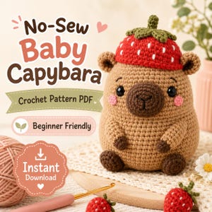Może przedstawiać: Szydełkowana maskotka amigurumi przedstawiająca małą kapibarę w czerwonej czapce truskawce z zielonymi listkami. Tekst głosi No-Sew Baby Capybara, Crochet Pattern PDF, Beginner Friendly oraz Instant Download. Kapibara ma brązowe futerko i czarne oczy.