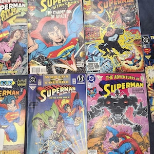 Peut inclure: Une collection de sept bandes dessinées vintage Superman présentant des illustrations graphiques colorées sur les couvertures. Les titres incluent The Adventures of Superman, Action Comics et Superman The Man of Steel, montrant diverses scènes d'action.