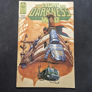 May include: A vintage comic book titled The Light and Darkness War, issue two of six, featuring a large, tan, organic-looking ship with blue metallic plating and a green helicopter flying below it against a warm, orange-toned background.