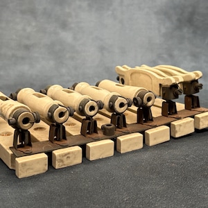 May include: A vintage electrical component assembly featuring a series of off-white ceramic cylindrical insulators mounted on a rectangular base. The insulators are secured with dark metal brackets and hardware, showing signs of age and oxidation.