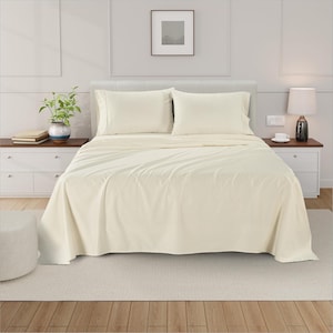 May include: A cream-coloured bed sheet set on a bed, including a fitted sheet, flat sheet, and two pillowcases. The sheets are neatly arranged, with the top sheet folded over. The bed is made up with a neutral colour palette, creating a calming and inviting atmosphere.