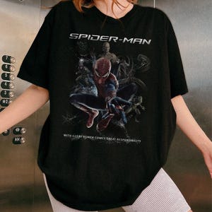 May include: Black Spider-Man t-shirt with a graphic of the superhero and the text "SPIDER-MAN" above and "WITH GREAT POWER COMES GREAT RESPONSIBILITY" below. The t-shirt has a crew neck and is a classic fit.