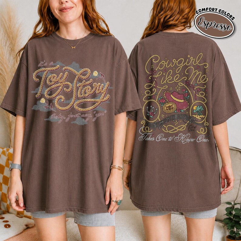 K&ouml;nnte beinhalten: Ein kurz&auml;rmeliges T-Shirt in Espresso-Braun mit einer Vorderseite, die den Schriftzug "Toy Story" und "baby, just say yes" in Seiloptik zeigt. Die R&uuml;ckseite zeigt "Cowgirl like me" und "Takes One to Know One" mit Western-Illustrationen.