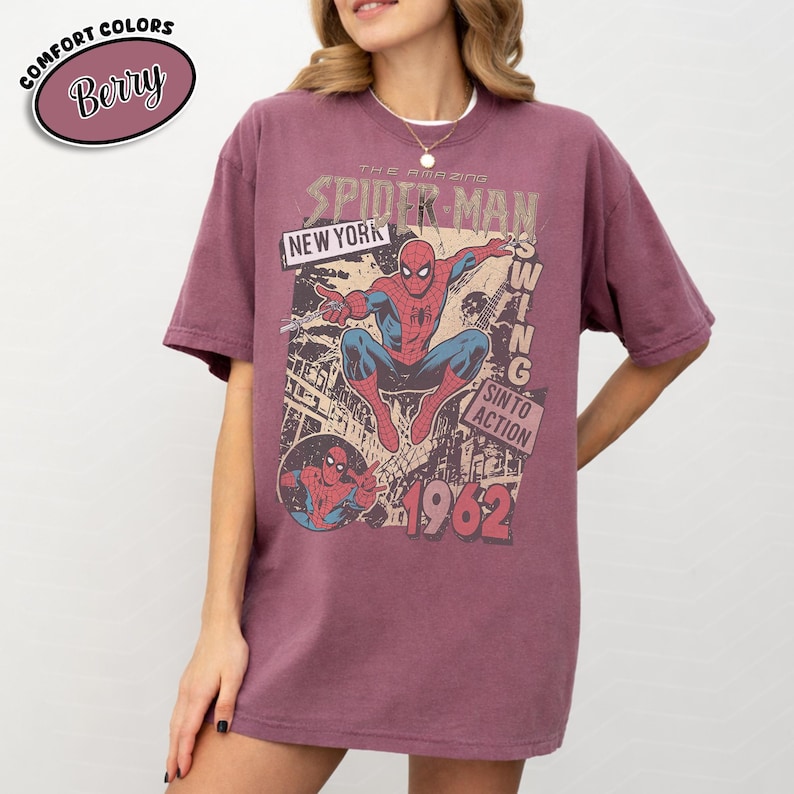 Puede incluir: Camiseta color bayas con un gr&aacute;fico vintage de Spider-Man. El dise&ntilde;o incluye el texto "THE AMAZING SPIDER-MAN", "NEW YORK" y "1962". La camiseta es de color confort y tiene un corte relajado.