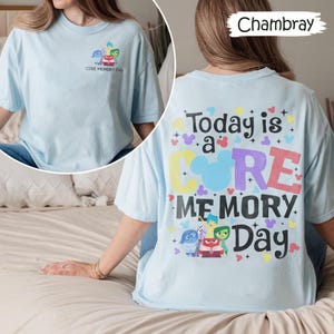 May include: Pale blue t-shirt with a graphic on the front and back. The front has a cartoon image and the text "CORE MEMORY Day." The back shows the text "Today is a CORE MEMORY Day" with cartoon characters.